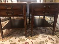 Front view of both side tables showing drawer fronts, brass pulls, inlay, and lower shelves
