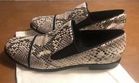 Side view of both snakeskin-pattern loafers on cloth