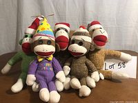 Group shot of all six sock monkey plush toys