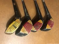 Club heads showing coloured inserts and wood construction
