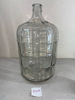 Front view of the 5 gallon glass carboy showing its cylindrical shape and ribbed design.