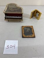 Photo showing the piano music box, ambrotype photograph in Union frame, and tiny folding clock.
