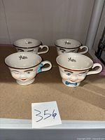 Four Baileys winking coffee cups with three having bow ties and one with pearls