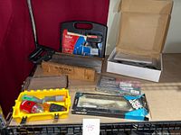 All items arranged on table showing overall lot contents including nailer, solder tool, saws, miter box, and tool case