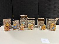 Overview photo of six Cherished Teddies figurines with all their boxes behind
