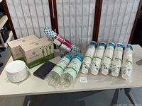 View showing two sealed Ecovita cutlery sets in green packaging, two stacks of plates, and 6 packs of Sustainable Earth hot cups.