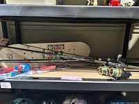 Three Surf System rods and two Penn reels at bench with Maple skateboard deck and Spider-Man rod package