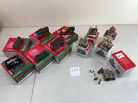 All Liberty Falls village ceramic miniatures arranged with six JCPenney Home Towne Express train pieces on top of branded boxes, showing the full collection and condition.