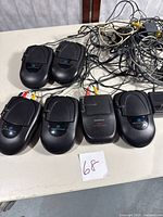 Six black RadioShack 2.4GHz wireless AV transmitter/receiver units with attached AV cables laid on a table, showing front labels and cable connections.