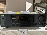 Front view of black Onkyo TX-8211 stereo receiver showing power button, headphone jack, display and volume control knob.