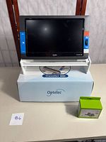 Optelec Traveller HD magnifier on stand next to Nova walker glide skis in box