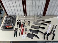 Full overview of the lot including trays with silverware, kitchen tools like scissors and can openers, plastic utensil organizer, and a metal napkin holder.