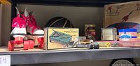 Photo showing the white Roller Derby quad roller skates with neon pink wheels and laces, and mini pool table box, basketball, and boxed games.