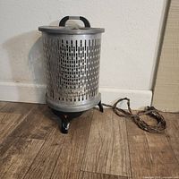 Front view showing cylindrical body, base, and top handle