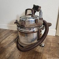 Overall view of Filter Queen canister vacuum with hose attached
