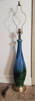 Full view of tall drip-glaze lamp showing ceramic body, base, harp and socket