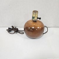 Lamp front view showing spherical wood base and cord