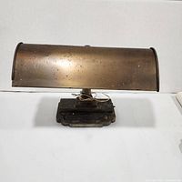 Front view of bronze desk lamp showing curved shade and base