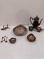 Group shot showing coffee pot, sugar, creamer, shell bowls, spoons, trinket dish
