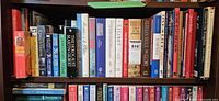 Shelf with books on royalty and historical topics, hardcover and paperback mixed.