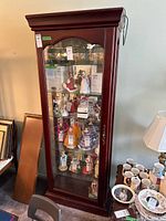 Full front view of the wood display cabinet showing glass door and interior with shelves and keyhole handle
