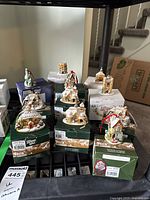 Eleven Lilliput Lane Christmas ornaments each displayed on top of their original boxes showing variety and detail of the collection.