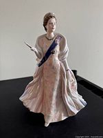 Front view of the porcelain figurine showing facial features, sash, and dress