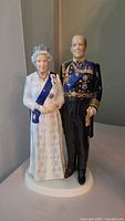 Front view of entire porcelain figurine showing both figures, facial details, sash and uniform.