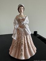 Front view of the porcelain figurine showing peach gown and gold detailing