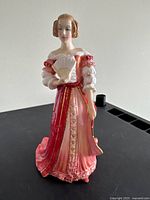 Front view of figurine showing gown and fan
