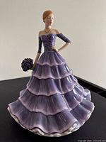 Front three-quarter view showing full gown tiers and bouquet