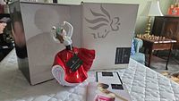 Full view of Royal Doulton Karen figurine next to its original box and documentation.