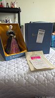 Figurine seated in original Royal Doulton box with certificate in foreground