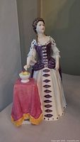 Front view of the figurine showing bodice, skirt and fruit bowl on table