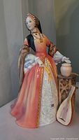 Full front view of the figurine displaying the gown, accessories, and overall height