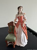 Front view of full figurine and chair on black surface