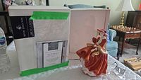 Original box of Royal Doulton figurine with certificate of authenticity inside visible through packaging finish