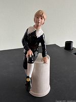 Front view of the Royal Doulton Little Lord Fauntleroy figurine sitting on a cylindrical base, showing the detailed painted face and outfit.