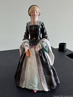 Front view of figurine showing gown, book, and facial detail