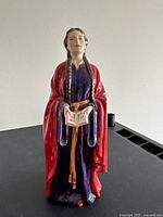 Front view of figurine showing Matilda holding book