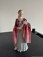 Front view of the Olivia figurine showing full figure, painted dress, and flowers held.