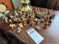 Wide view of Wade ceramic figurines arranged on table showing over 40 pieces including animals and other figures