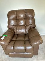 Front view of the brown leather La-Z-Boy recliner chair showing padded cushions and armrests.
