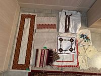 Full overview of the lot including all linens and embroidered shirt arranged on floor.