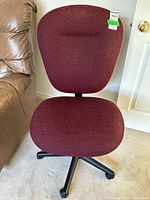 Front view of maroon upholstered swivel office chair with resin base and wheels