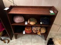 Angled view of vintage wood shelving unit showing both shelves and side supports with nicks, scratches, and general wear.