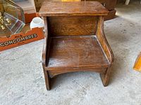 Front view of wooden step stool showing flat top and single step