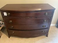 Front view of mahogany dresser showing curved front and four drawers