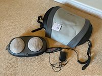 Full view of Comfort Products lumbar electric massager, controller and power adapter on carpet.