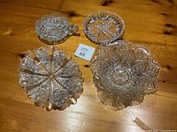 Four pieces of crystal and cut glass serving bowls and dishes with intricate patterns and design variations